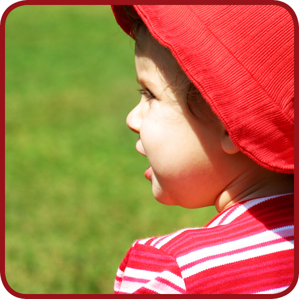 een kind buiten met een hoed op in de zon